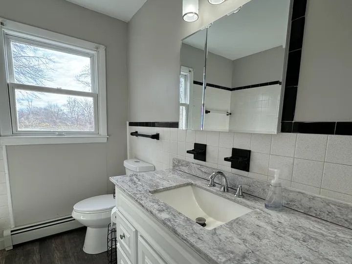 Updated bathroom with granite-topped vanity and framed mirror in the Lebanon, CT home