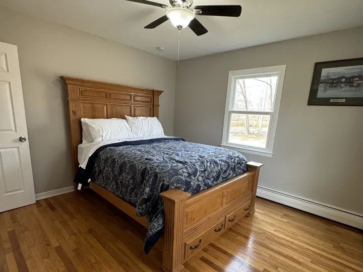 Main-floor bedroom with hardwood floors and ceiling fan in Lebanon, Connecticut