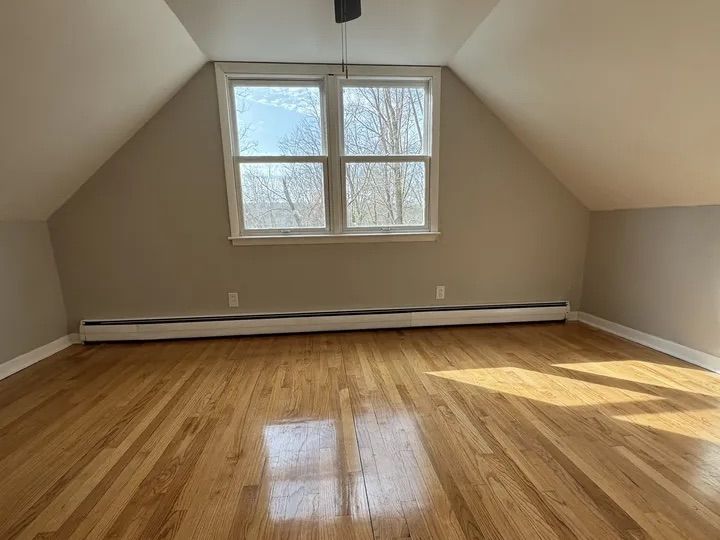 Upstairs Cape bedroom with vaulted ceiling and refinished hardwood floors