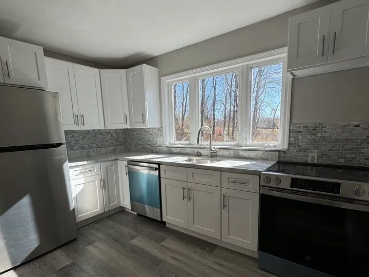 Renovated kitchen with white shaker cabinets, granite counters and stainless appliances in Lebanon, CT