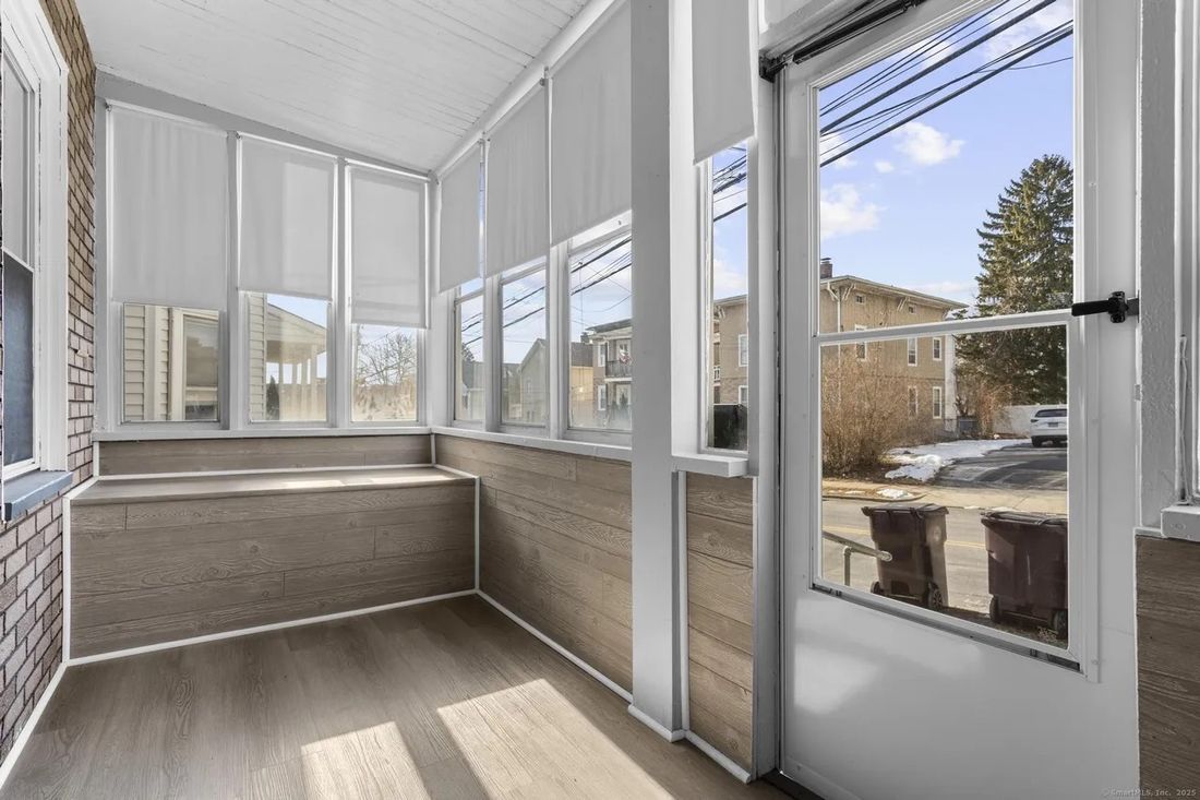 Enclosed sun porch with wraparound windows at the New Britain, CT multi-family property
