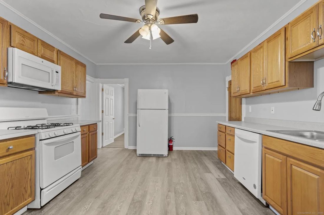 Updated kitchen in one unit of the New Britain triplex with gas range, dishwasher and oak cabinetry